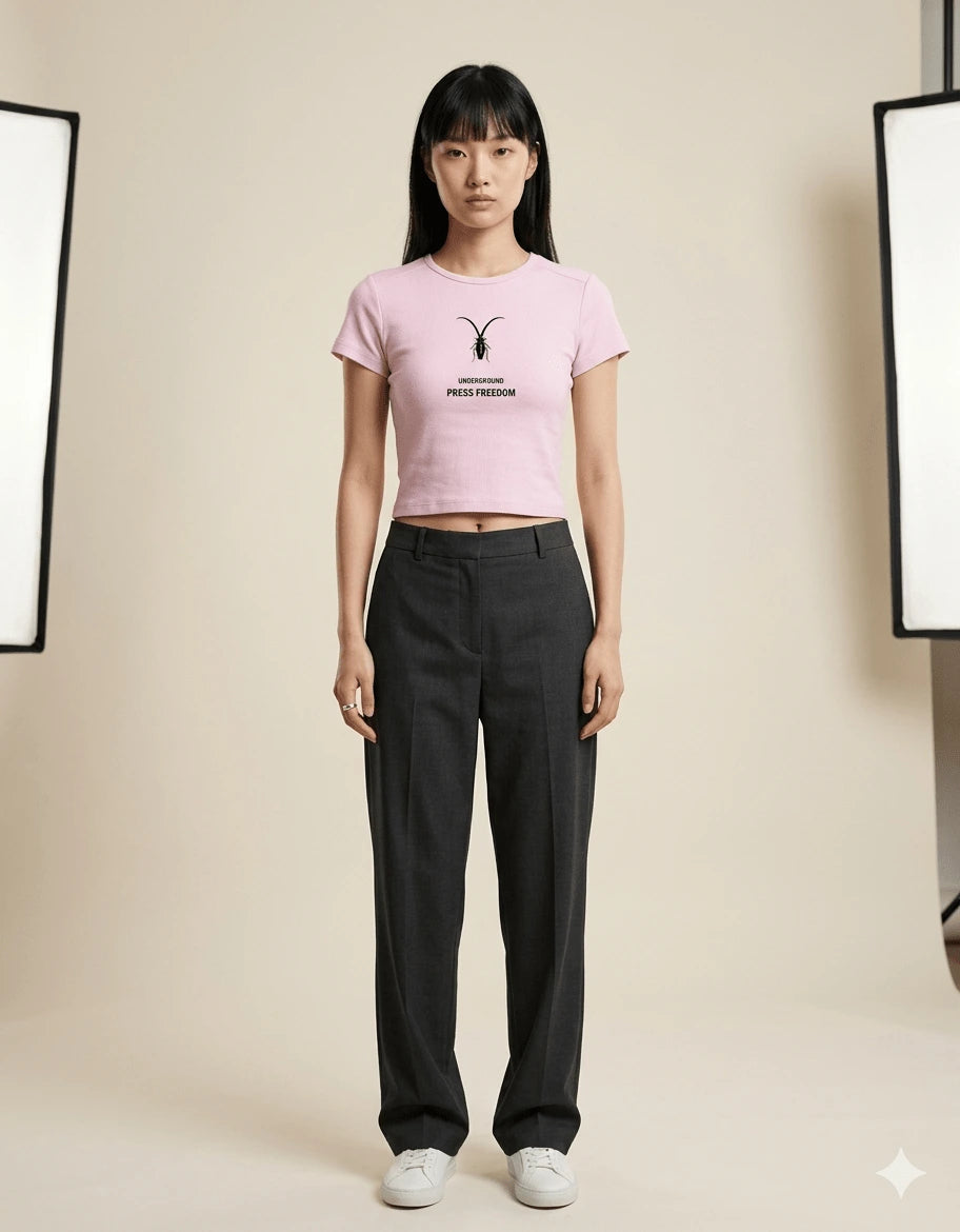 Front view of the Roach Resistance Press Freedom pink baby tee for women, showcasing the fitted cropped silhouette.