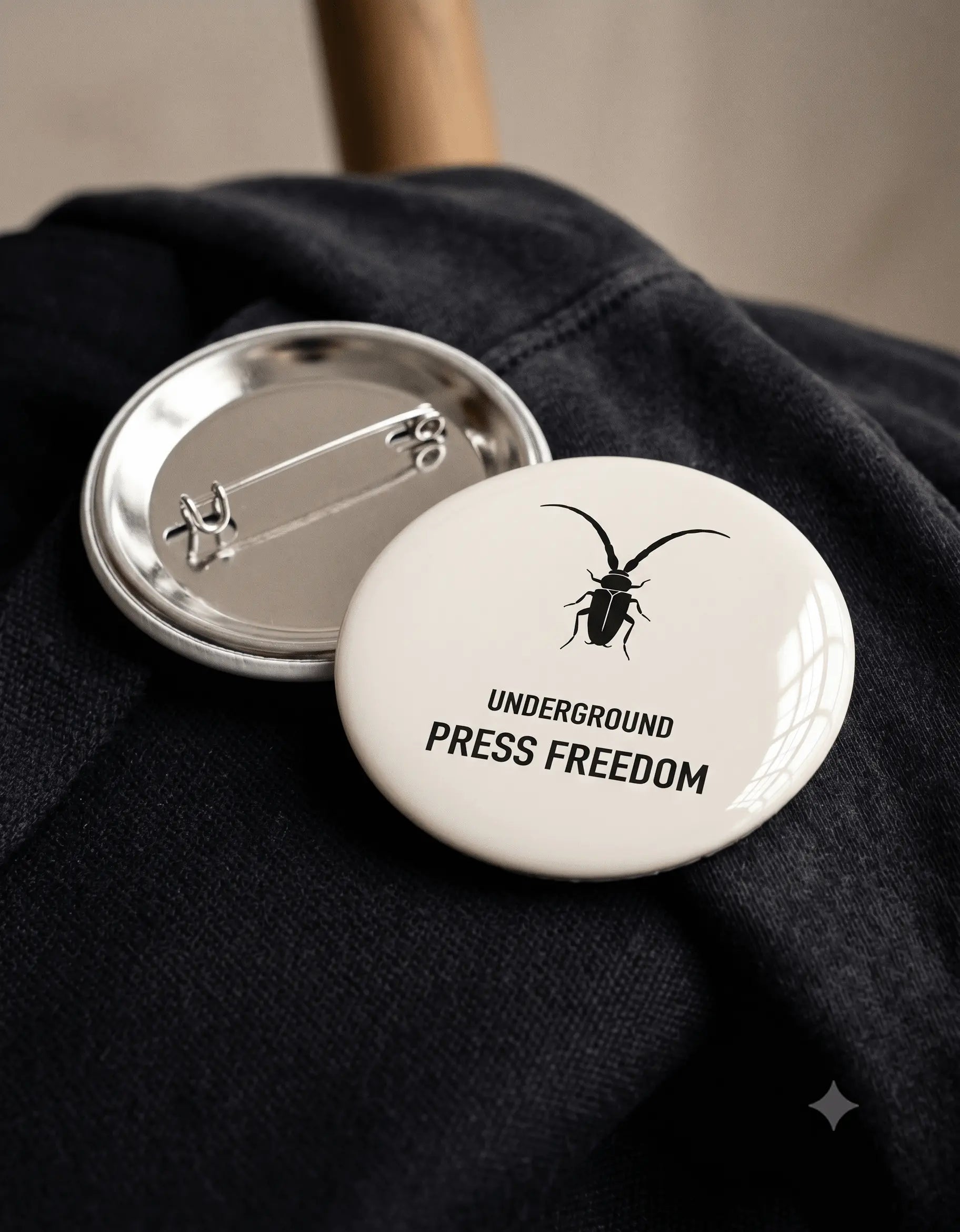 Close-up of the secure pin-back fastening on the Roach Resistance rust-free metal badge.