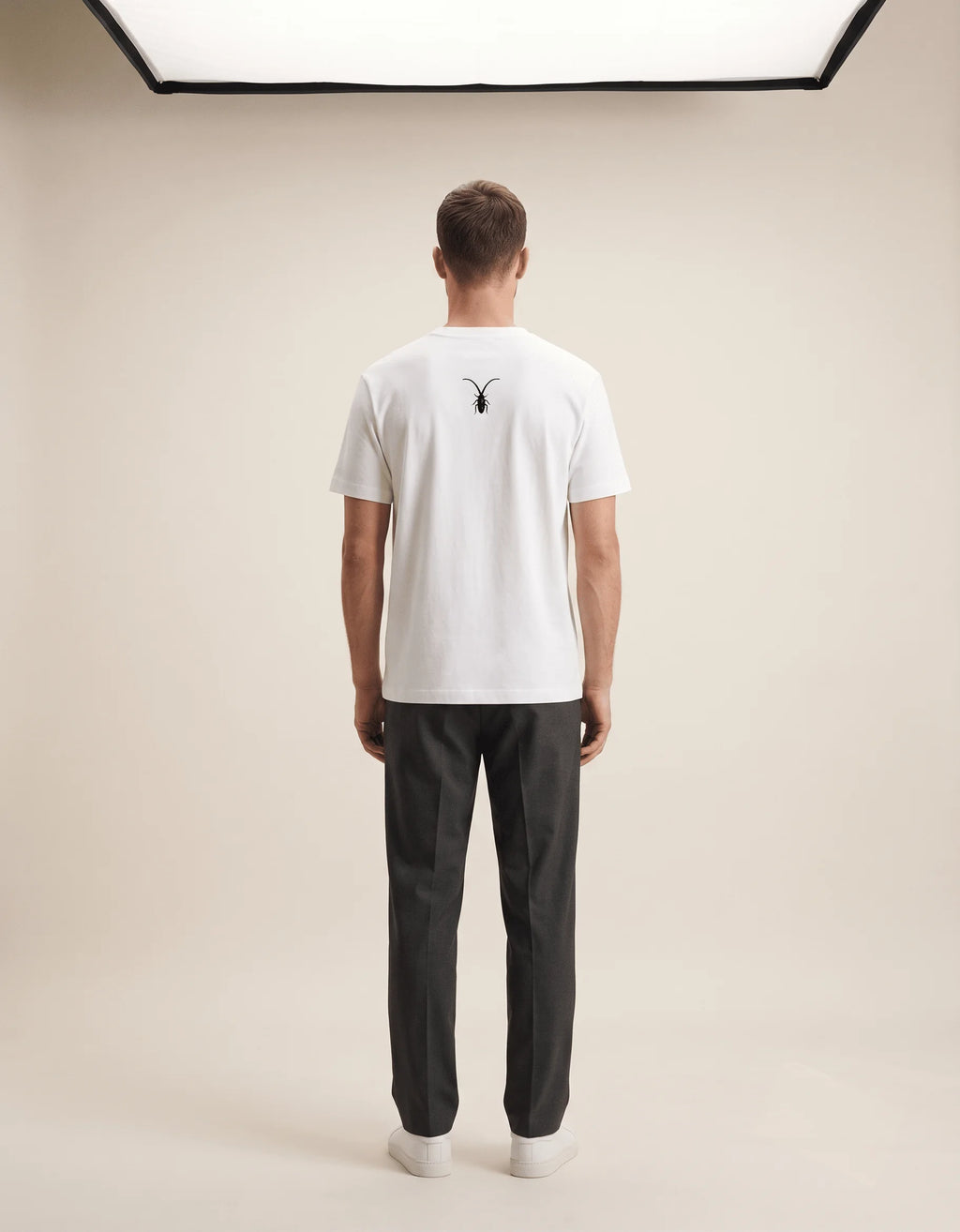Studio back display of a pristine white luxury unisex t-shirt in regular fit Supima cotton from the Roach Resistance Press Freedom collection.