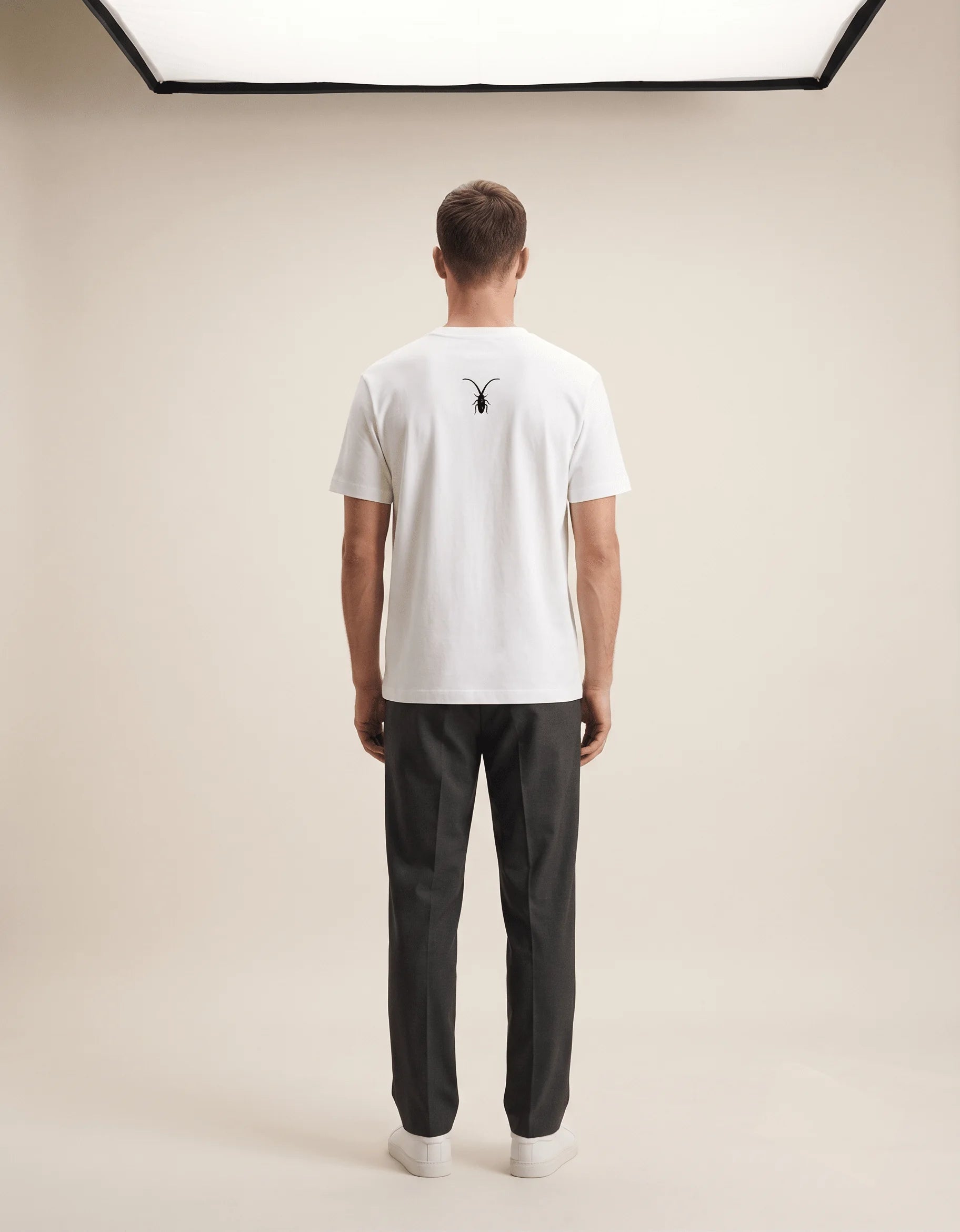 Studio back display of a pristine white luxury unisex t-shirt in regular fit Supima cotton from the Roach Resistance Press Freedom collection.