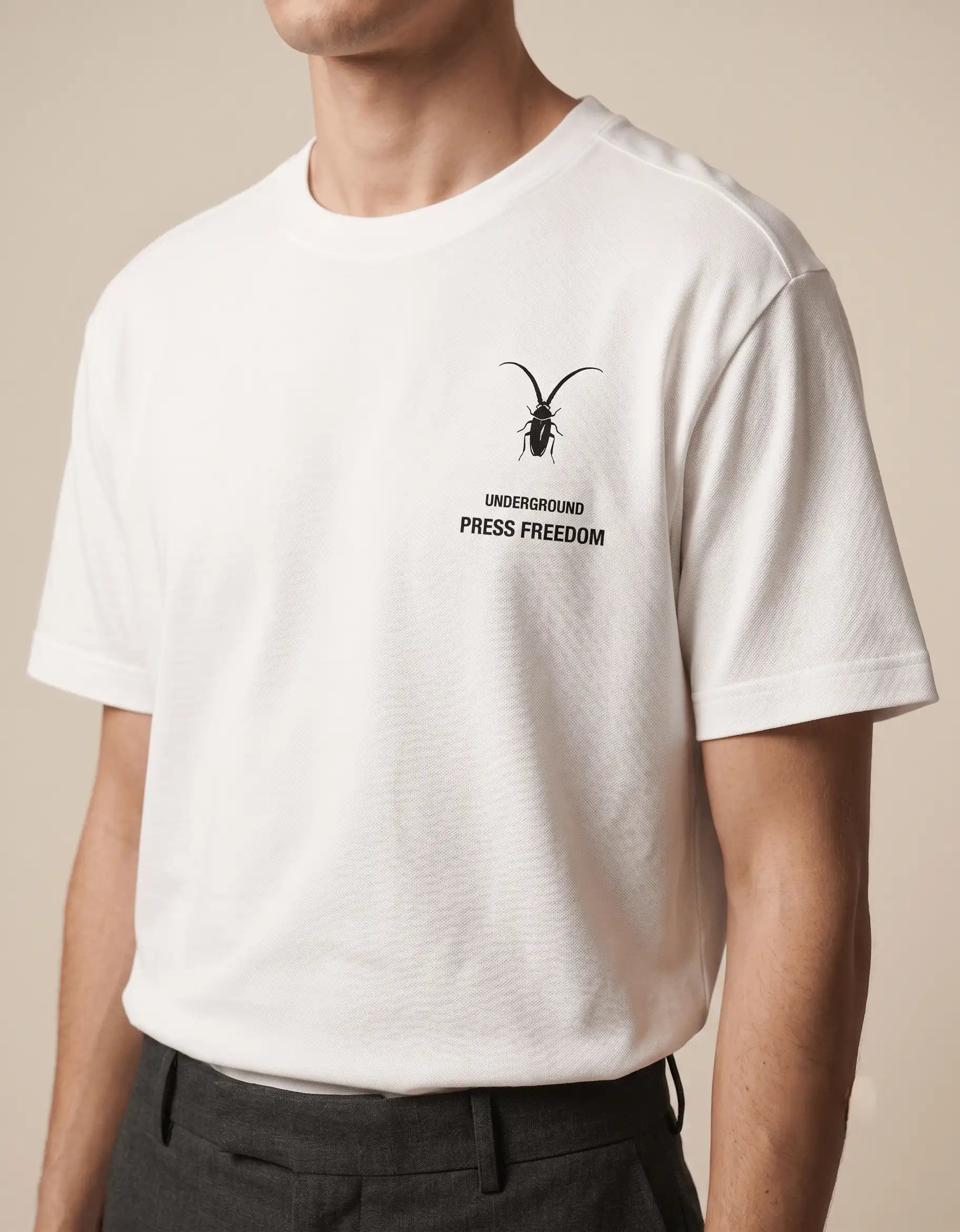 Studio display of a pristine white luxury unisex t-shirt in regular fit Supima cotton from the Roach Resistance Press Freedom collection.