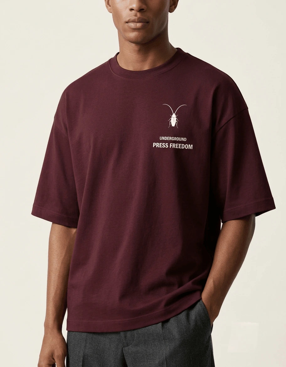 Premium maroon unisex oversized terry-knit t-shirt by Roach Resistance, featuring a relaxed drop-shoulder fit. close-up 